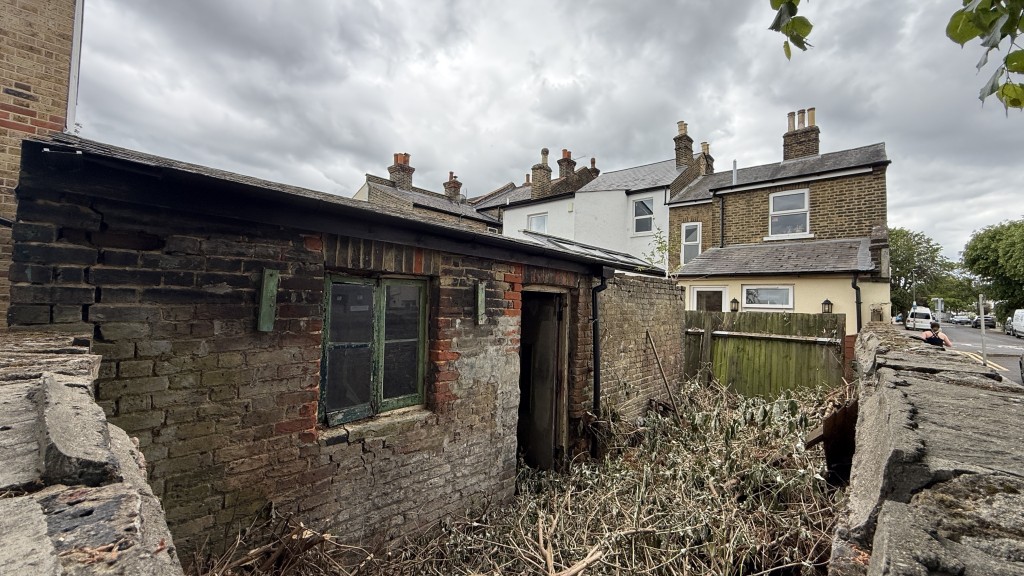 Lot: 62 - PARCEL OF LAND WITH EXISTING OUTBUILDING - External image of building over wall